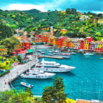 Colorful houses and luxury yachts line the picturesque bay of Portofino, Italy, creating a stunning coastal scene