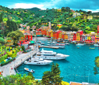 Colorful houses and luxury yachts line the picturesque bay of Portofino, Italy, creating a stunning coastal scene