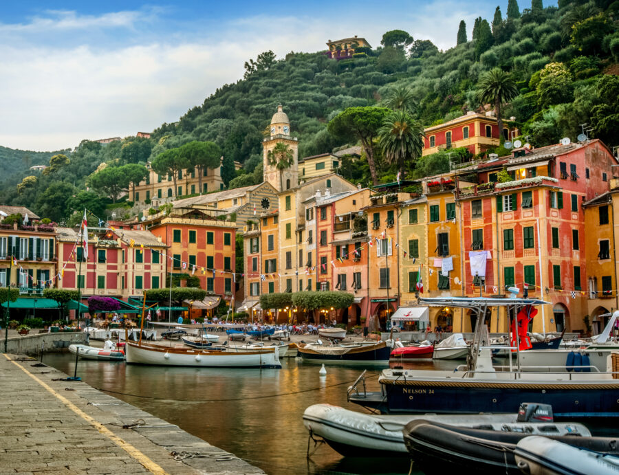 Portofino's vibrant harbor features colorful houses and boats set against the stunning backdrop of the Mediterranean Sea