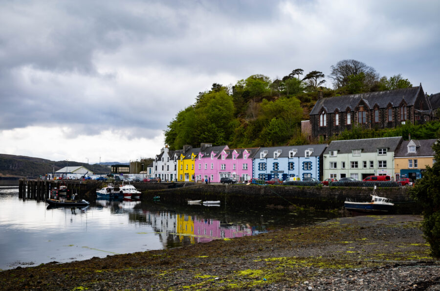 Cloudy sky over Portree Harbour, Isle of Skye, creating a moody atmosphere above the tranquil waters.