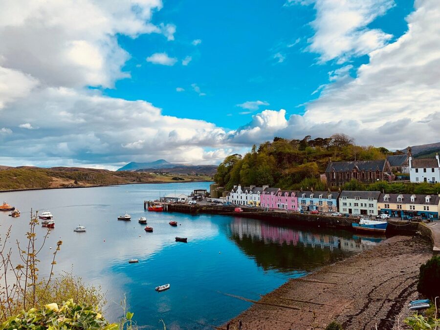 Portree, the picturesque capital of the Isle of Skye, showcases colorful buildings along the harbor against a scenic backdrop.