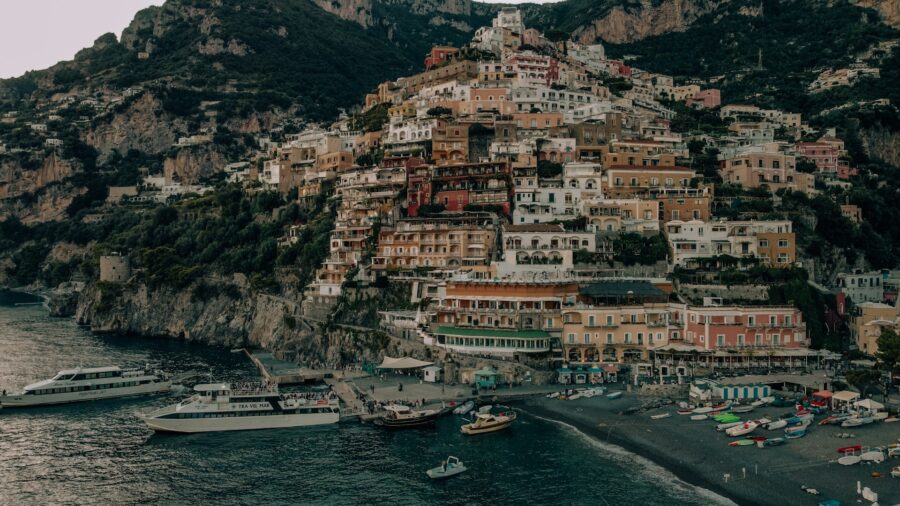 Aerial view of colorful Positano village on the Amalfi Coast with boats and cliffs.