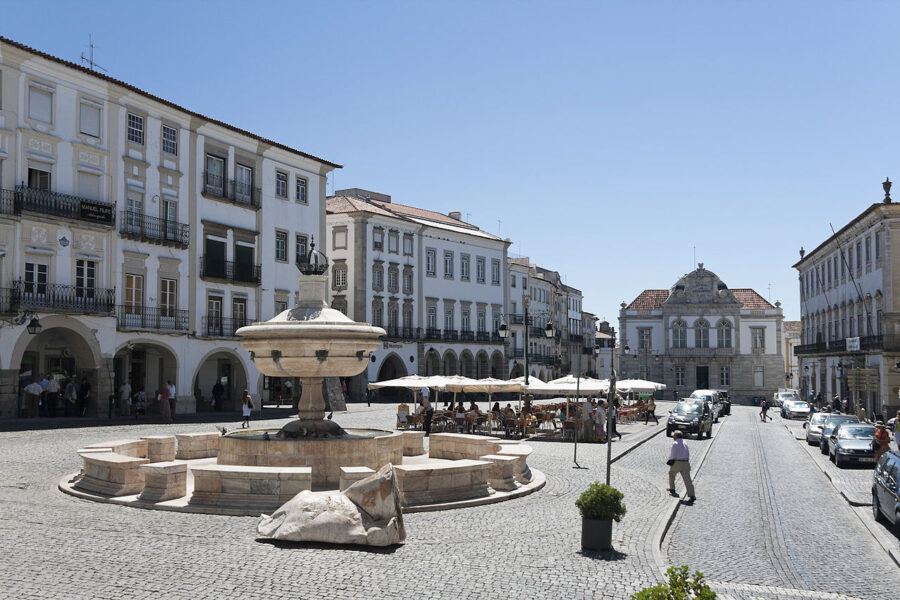 Fountain in Praça do Giraldo, Évora Alentejo, with a historic building visible in the background.