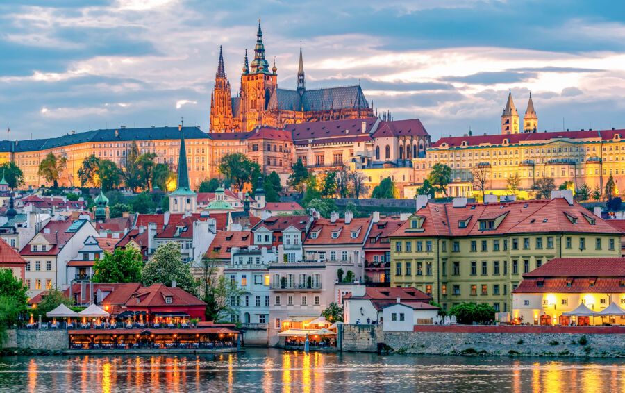 Prague Castle and St. Vitus Cathedral at sunset over Mala Strana, Vltava River, Czech Republic.