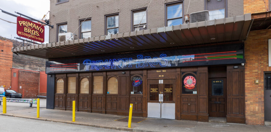 Exterior view of Primanti Bros Restaurant in Pittsburgh, showcasing its iconic signage and bustling street atmosphere