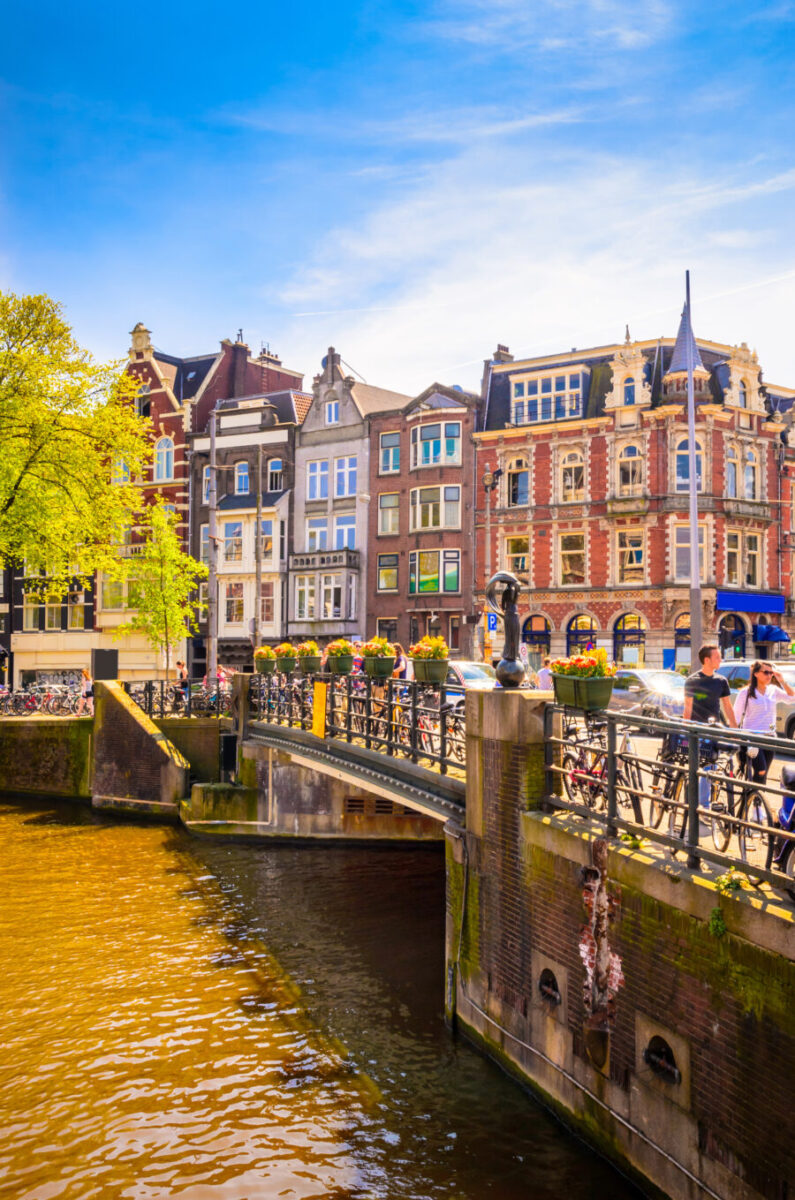 Scenic view of Prinsengracht Canal in Amsterdam, featuring historic buildings and boats along the waterway.