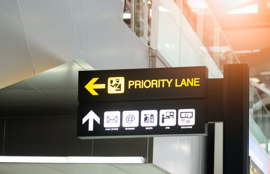 Modern airport Priority Lane sign with travel icons for efficient navigation.