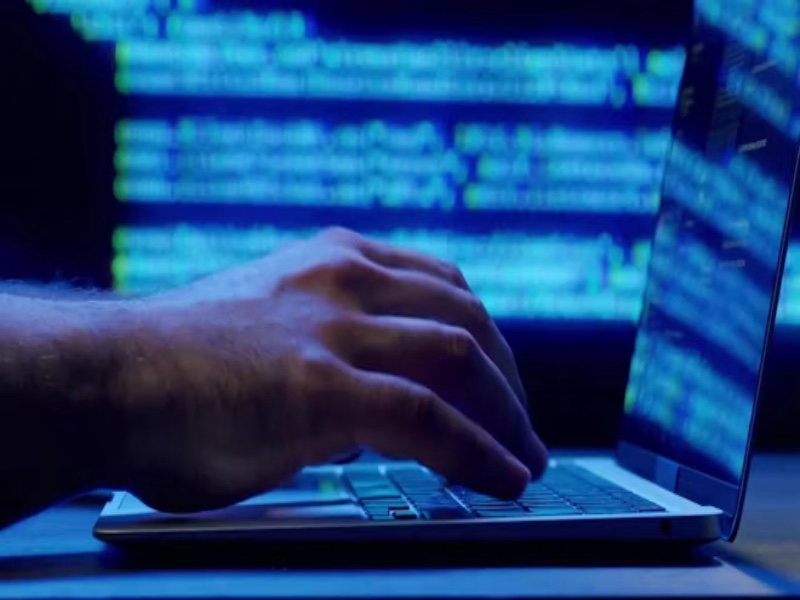 Person typing code on laptop with glowing blue screen, programming, cybersecurity, and AI savings optimization.