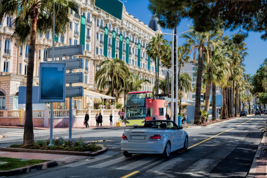 Scenic view of Promenade de la Croisette in Cannes, lined with palm trees, luxury shops, and the Mediterranean Sea