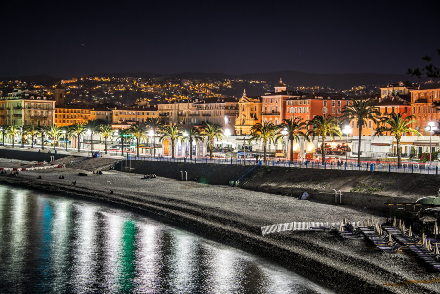 Dusk view of Nice's vibrant cityscape in the French Riviera, showcasing lights and buildings against a twilight sky.