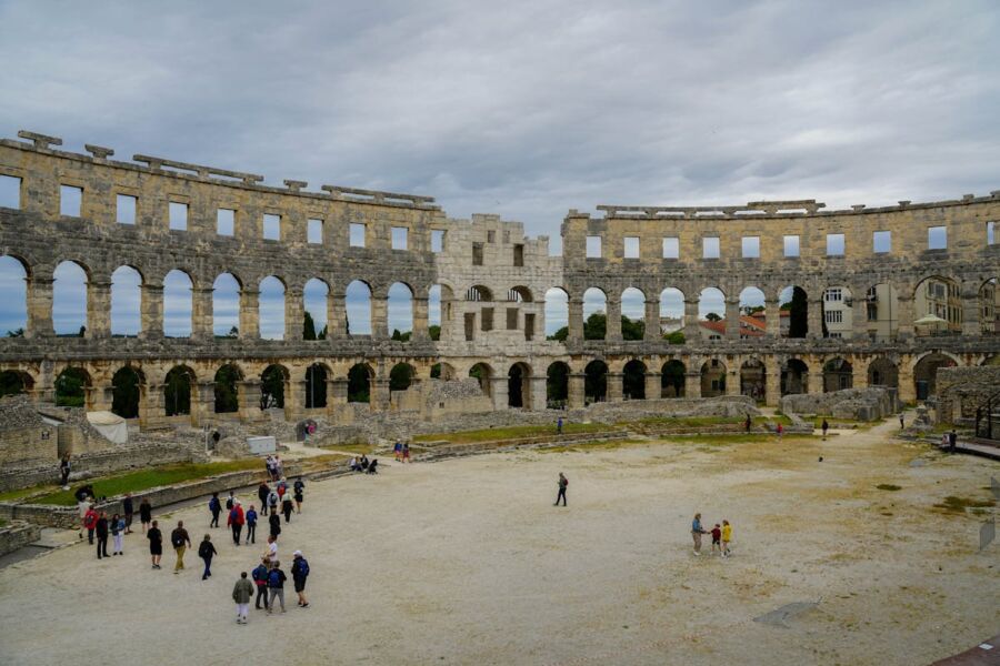 Pula Arena amphitheater with tourists, ancient Roman architecture, historical site exploration.