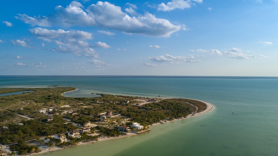 Aerial view of Punta Cocos, a small island with a sandy beach, surrounded by turquoise waters in Isla Holbox, Mexico.
