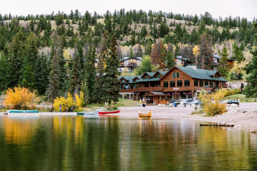 Pyramid Lake Lodge on the shore of a lake, with boats floating in the water, surrounded by scenic natural beauty.
