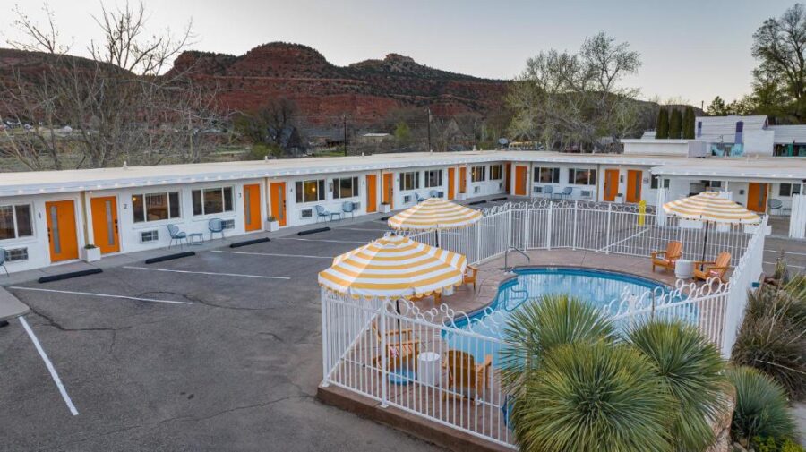 Exterior view of Quail Park Lodge in Utah, featuring a pool and patio area for guests to enjoy.