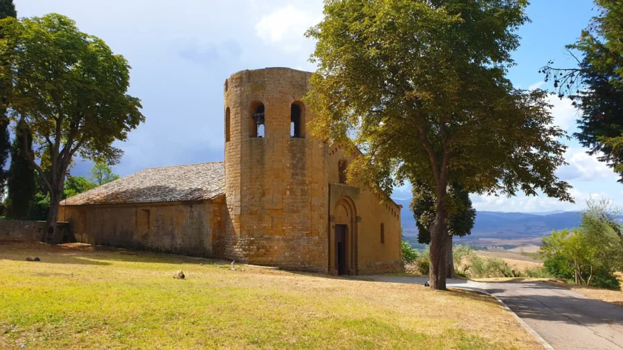 Charming stone church in lush countryside with bell tower and scenic pastoral landscape.