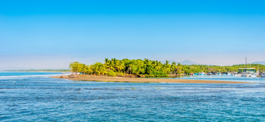 Scenic view of lush nature near the coast of Quepos town, Costa Rica, showcasing vibrant greenery and ocean waves