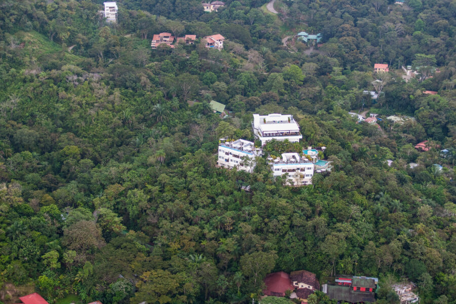 Scenic view of luxurious mansions in the tranquil suburb of Quepos, Costa Rica, surrounded by lush landscapes and palm trees