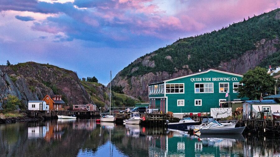 Quidi Vidi Brewery in St. John's, Canada, overlooking a harbor filled with boats and charming houses by the water