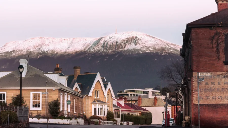 Historic Battery Point street with heritage houses and snow-capped mountain at sunrise in Tasmania.