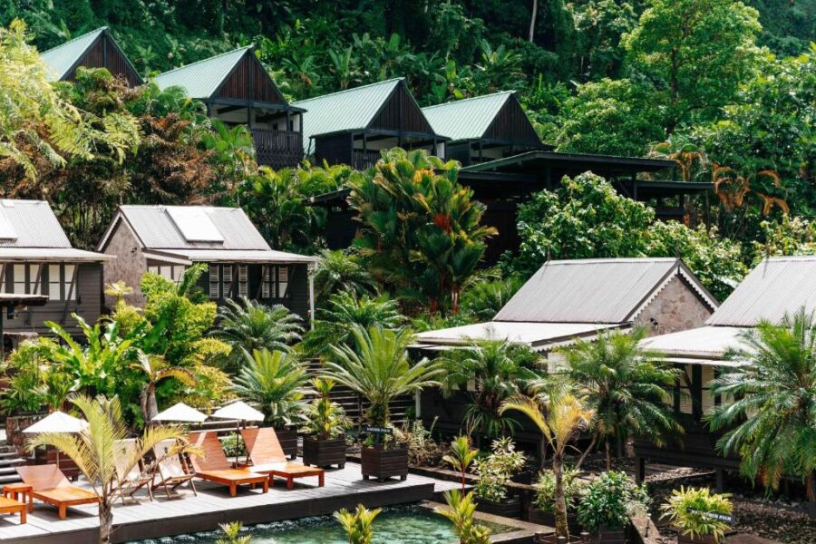 Rabot Hotel's pool, surrounded by lush tropical trees in Saint Lucia, showcasing a serene resort atmosphere.
