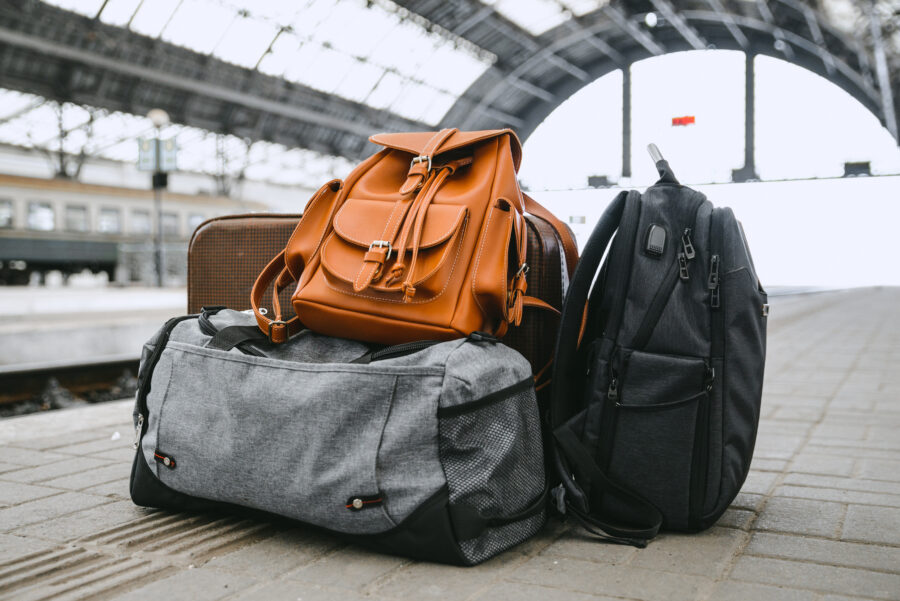 Luggage and bags of various shapes and colors positioned at a railway station, highlighting travel essentials for commuters.