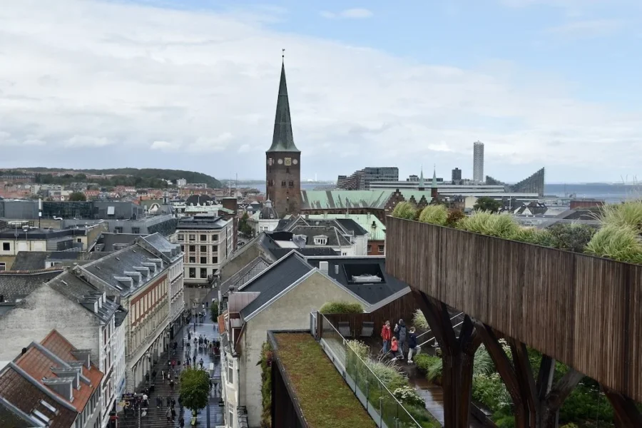 Aarhus rainy terrace city view with church tower and harbor skyline.