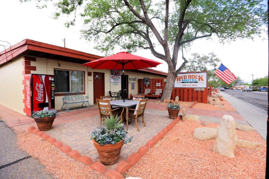 Cozy restaurant with red and white umbrellas, situated by the Red Rock Motel and Dam Motel.
