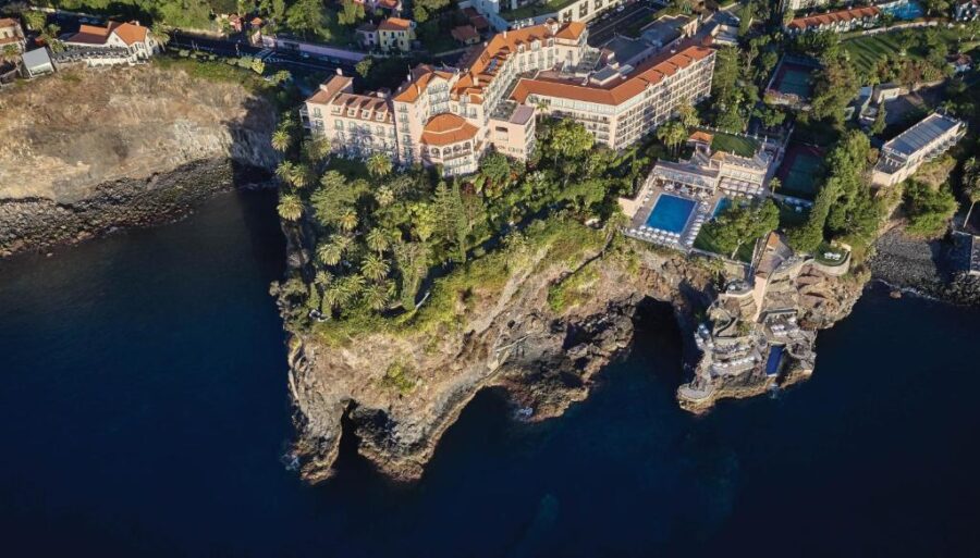Reid's Palace hotel on a cliff, offering stunning views of the ocean in Madeira.
