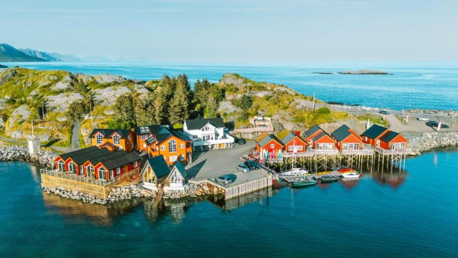 Scenic view of Reinefjorden Sjøhus in the picturesque village of Lofoten, Norway, surrounded by mountains and water.