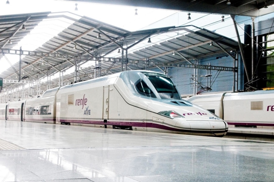 Renfe AVE high-speed train on glossy platform in modern station.