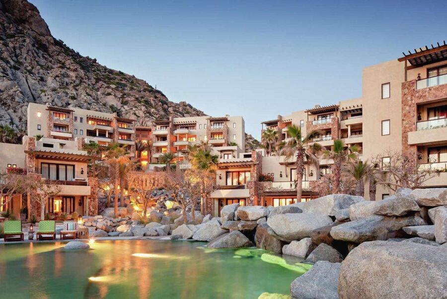 Luxurious resort with modern architecture, swimming pool, and mountain backdrop in Los Cabos.