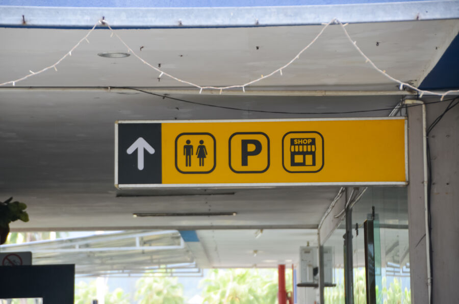 Sign displaying an upward arrow alongside male and female restroom symbols