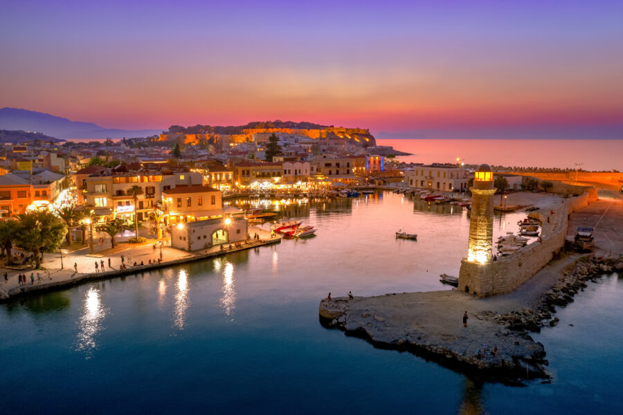 Scenic view of Rethymno's old Venetian harbor at night in Crete, showcasing historic architecture and calm waters