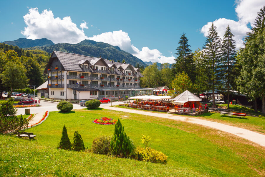 View of Ribcev Laz resort village's central street lined with hotels, set against the backdrop of Triglav National Park, Slovenia