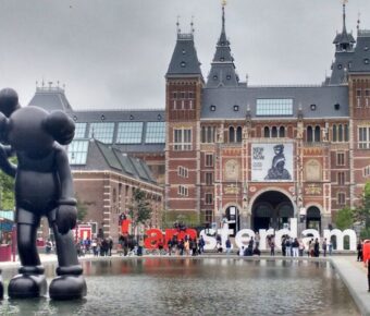 Amsterdams Rijksmuseum scene: Gothic architecture, I amsterdam sign, sculptures, visitors.