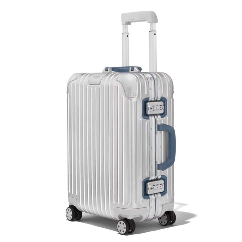 Side view of a silver aluminum Rimowa Cabin Twist suitcase with wheels against a white backdrop.