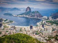 Aerial view of Rio de Janeiro cityscape, Sugarloaf Mountain, and scenic bay.