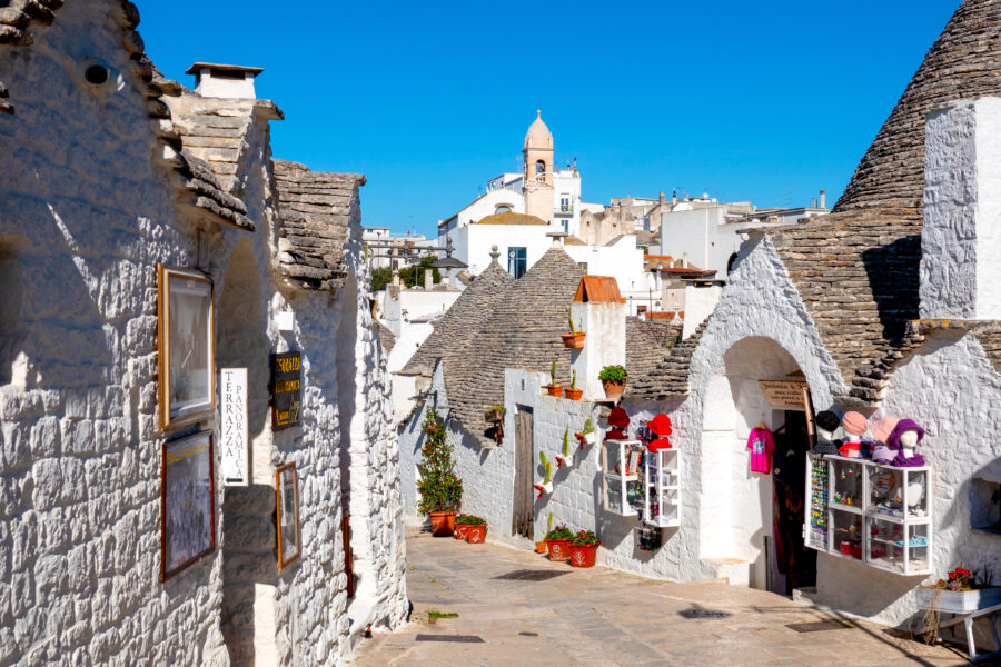 Scenic view of Rione Monti in Alberobello, Italy, showcasing traditional trulli houses with conical roofs.
