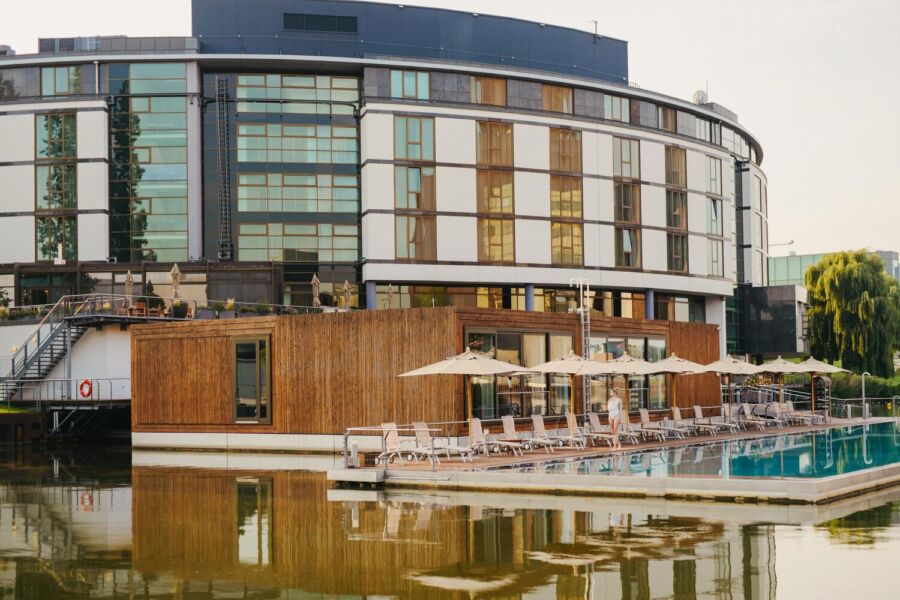 Luxurious waterfront Ritz Carlton hotel with modern architecture, swimming pool, and serene natural surroundings.