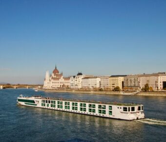 Hungarian Parliament Building seen from a Danube River cruise, showcasing its grandeur alongside the Budapest skyline