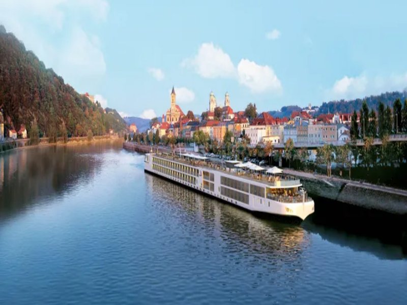 Passau Viking river cruise ship docked by picturesque riverside town.