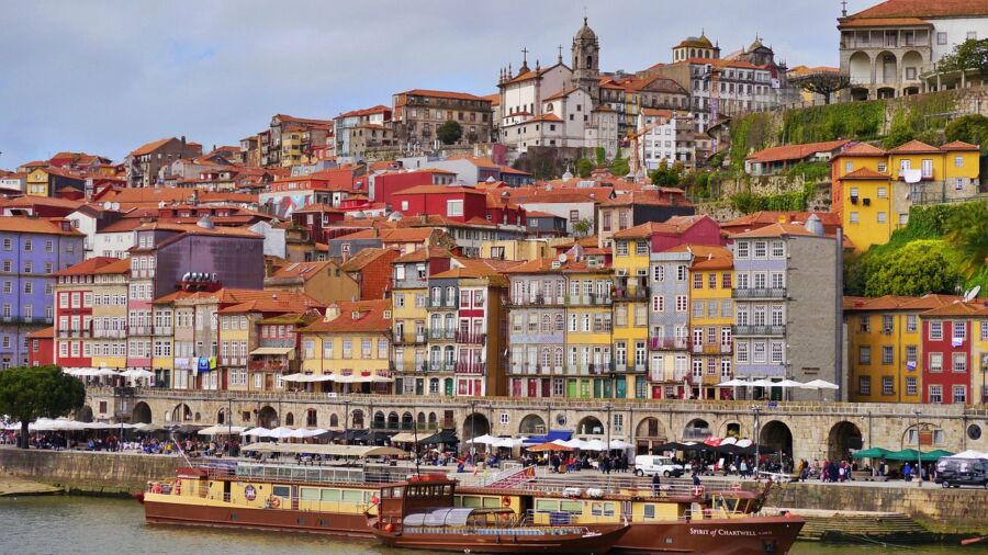 Picturesque Porto riverside view, Douro River, colorful buildings, historic architecture, vibrant culture.