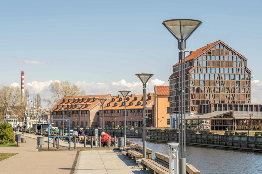 Scenic waterfront in Klaipėda: historic buildings, modern design, lively harbor, and peaceful pathways.