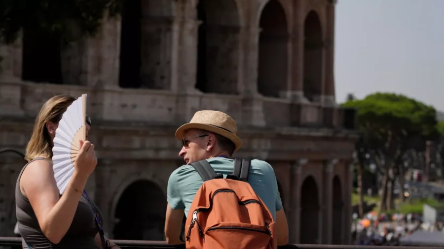 Tourists enjoying sunny Rome by the Colosseum with fan and backpack.