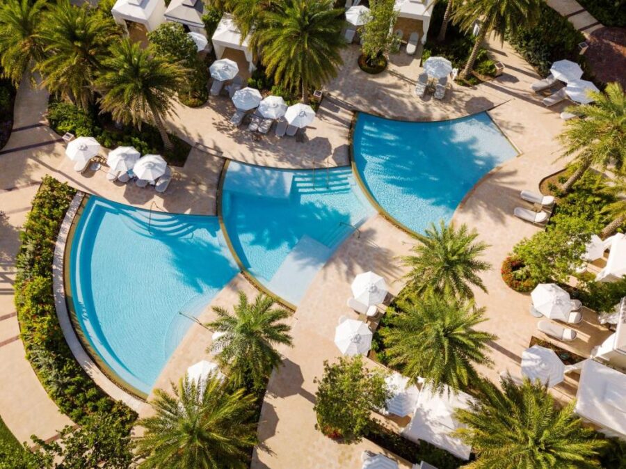 Aerial view of a pool surrounded by lush palm trees at Rosewood Baha Mar in Nassau, Bahamas.
