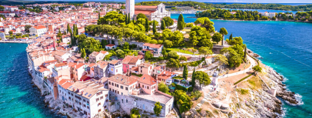 Aerial view of Rovinj's old town, showcasing colorful buildings, narrow streets, and the stunning coastline.