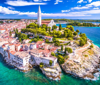 Aerial view of Rovinj's old town, showcasing colorful buildings, narrow streets, and the stunning coastline.