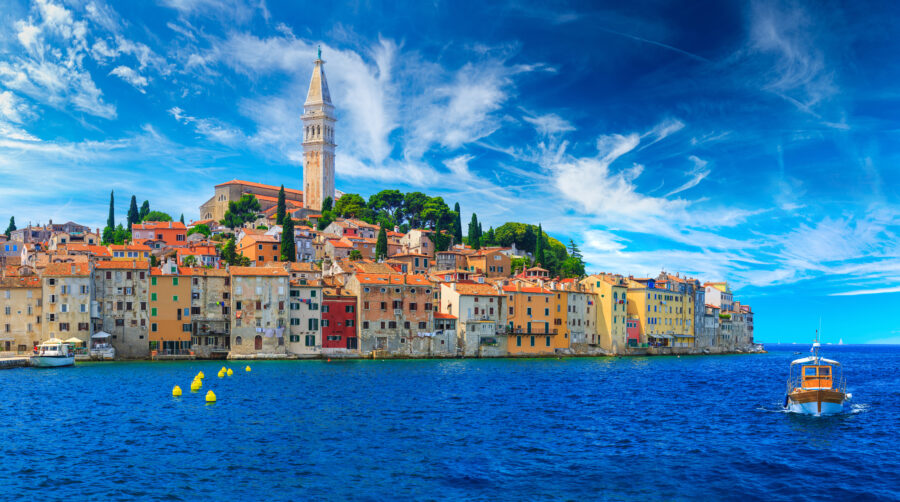 Romantic old town of Rovinj by the Adriatic Sea, featuring boats and yachts in a picturesque summer harbor scene.