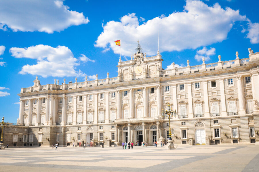 Exterior view of the Royal Palace in Madrid, Spain, showcasing its grand architecture against a clear skyline
