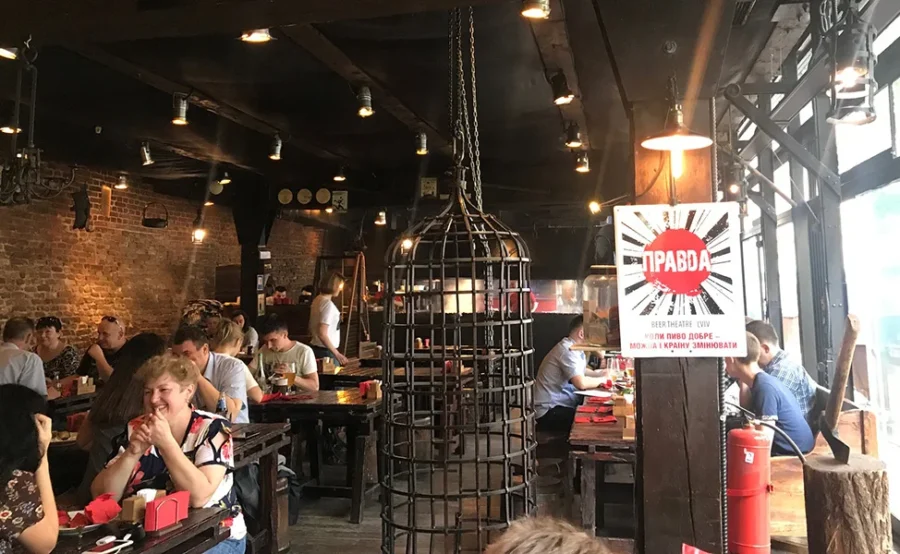 Cozy restaurant with rustic decor, exposed brick, and lively patrons in a warm atmosphere.